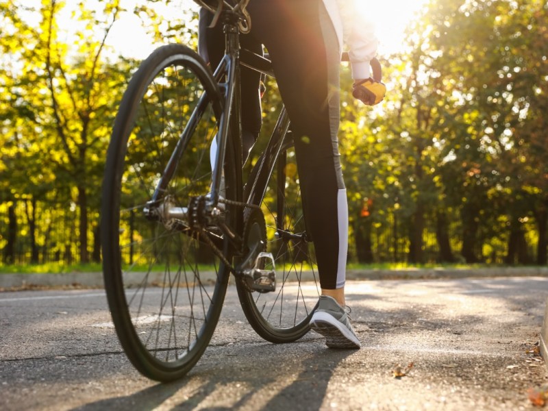 Eine Frau sitzt in freier Natur auf einem Fahrrad.