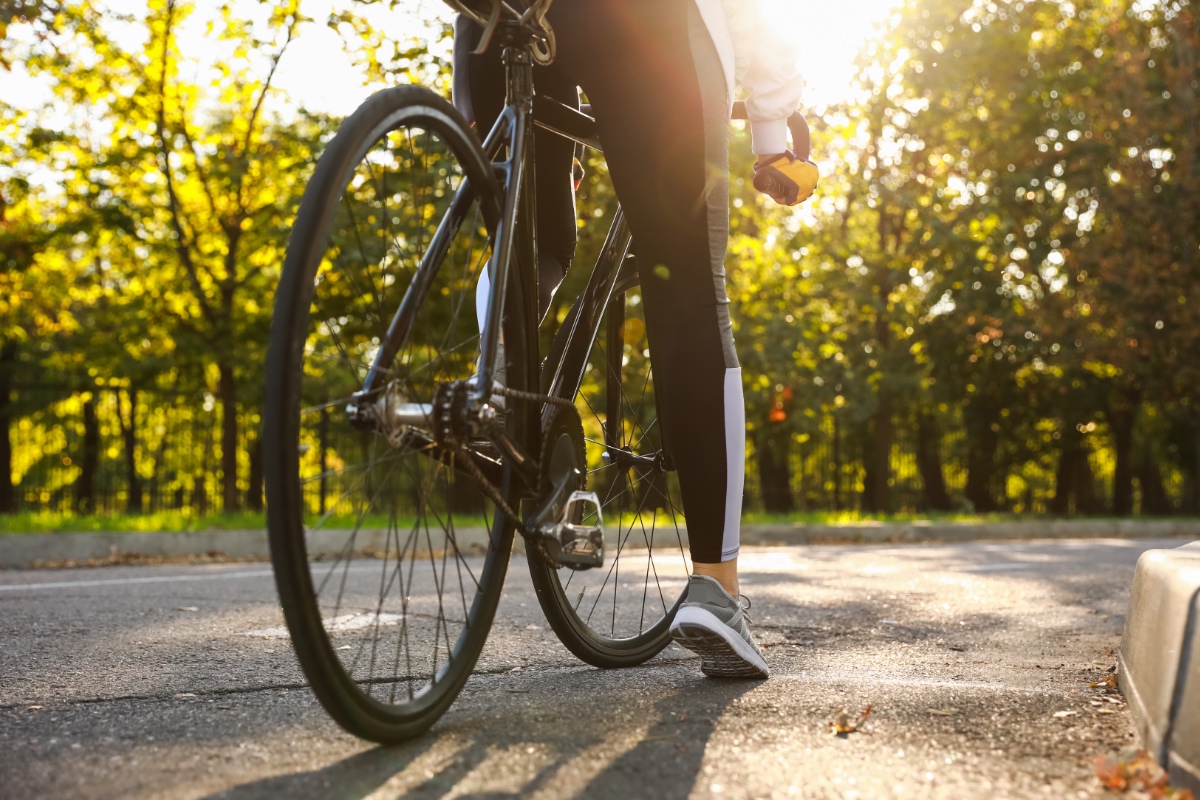 Eine Frau sitzt in freier Natur auf einem Fahrrad.