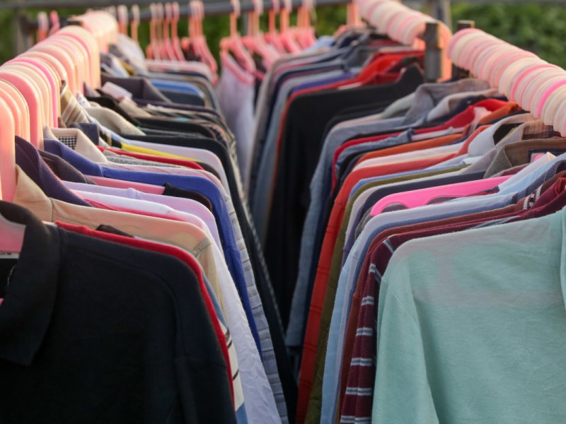 Hemden und Shirts auf Kleiderbügeln in einem Kleidergeschäft.