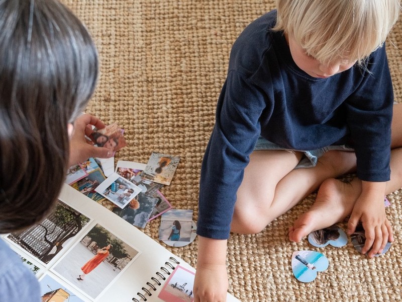 Eine Mutter bastelt mit ihrem Sohn an einem Fotoalbum.