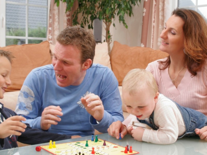 Vierköpfige Familie spielt Mensch ärgere dich nicht