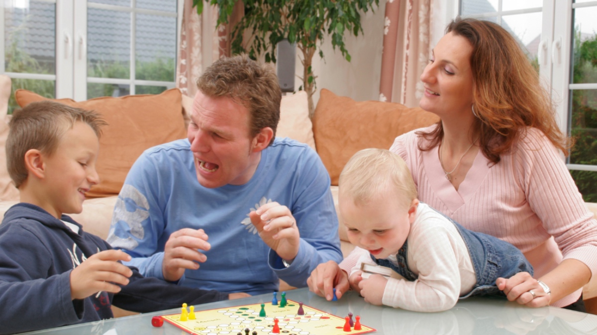 Vierköpfige Familie spielt Mensch ärgere dich nicht