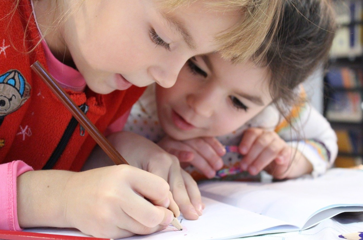 Zwei Grunschulkinder schreiben in Heft