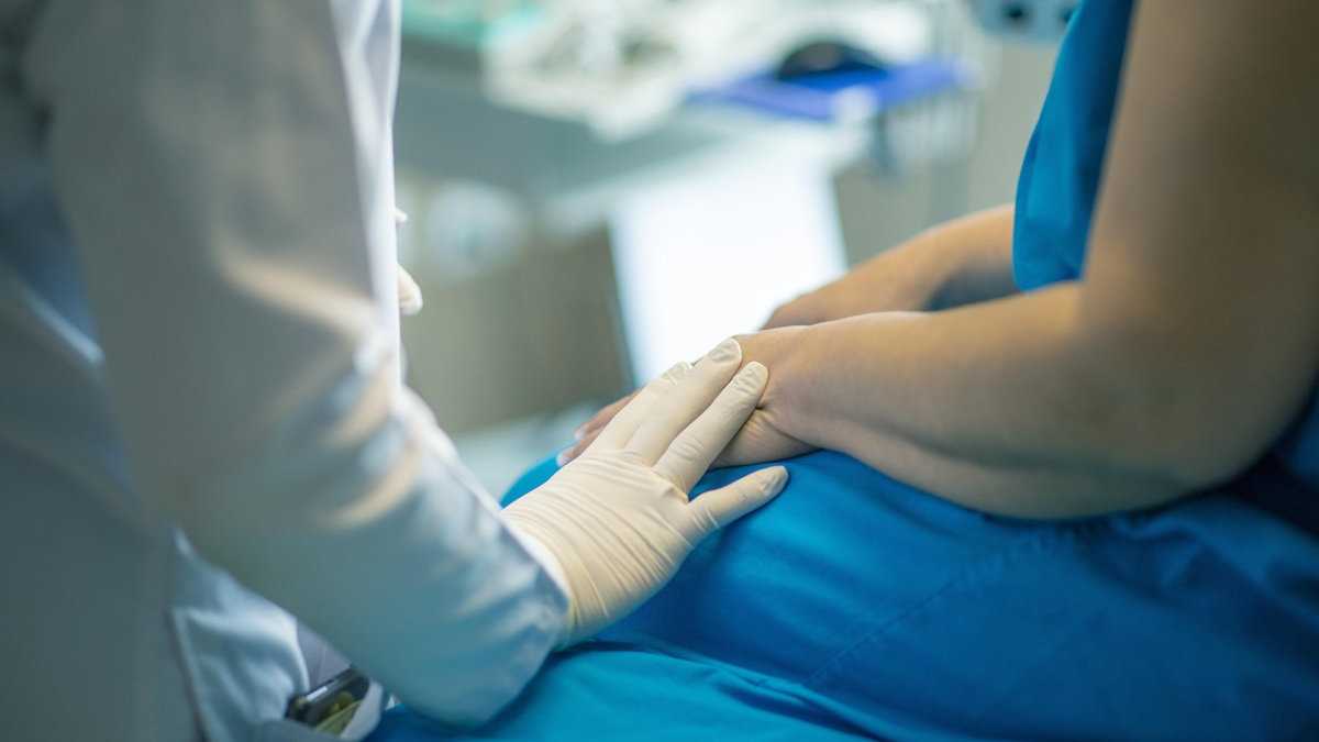 Ein Patient wird im Krankenhaus von einem Arzt im weißen Kittel untersucht.