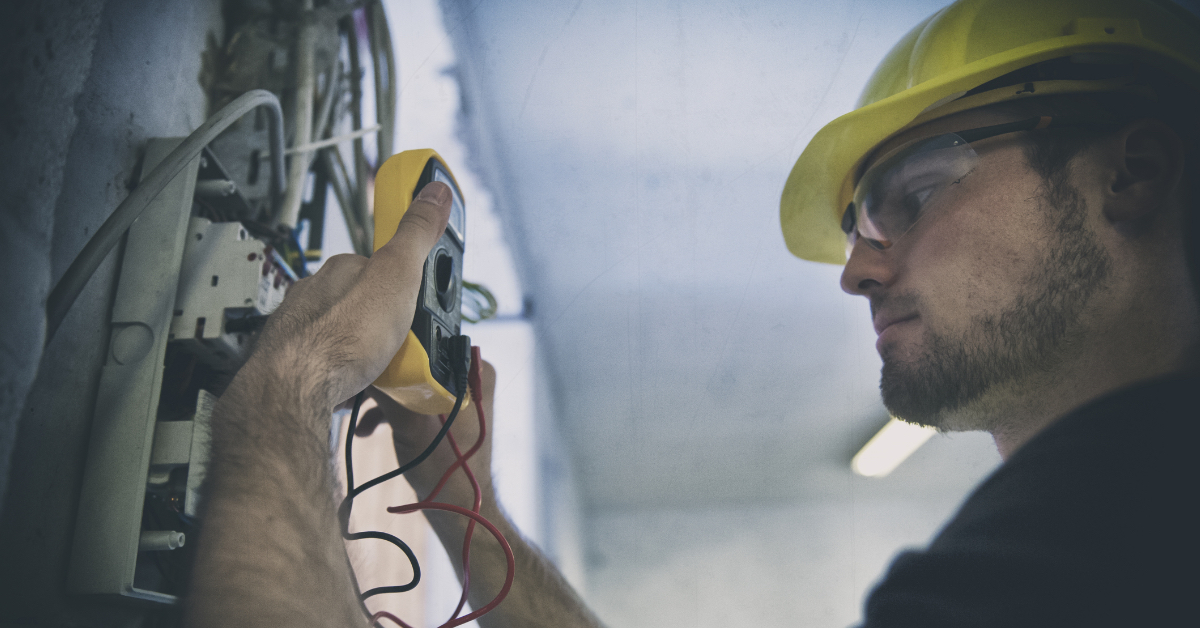 Ein Elektriker untersucht einen Sicherungskasten.