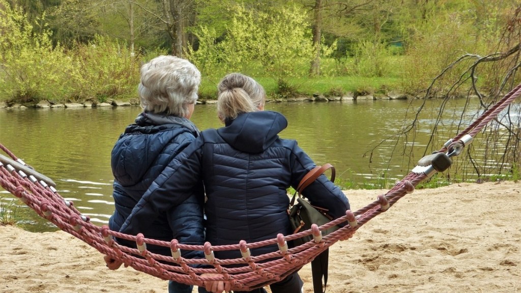 Eine ältere Frau sitzt mit ihrer Tochter auf einer Hängematte.