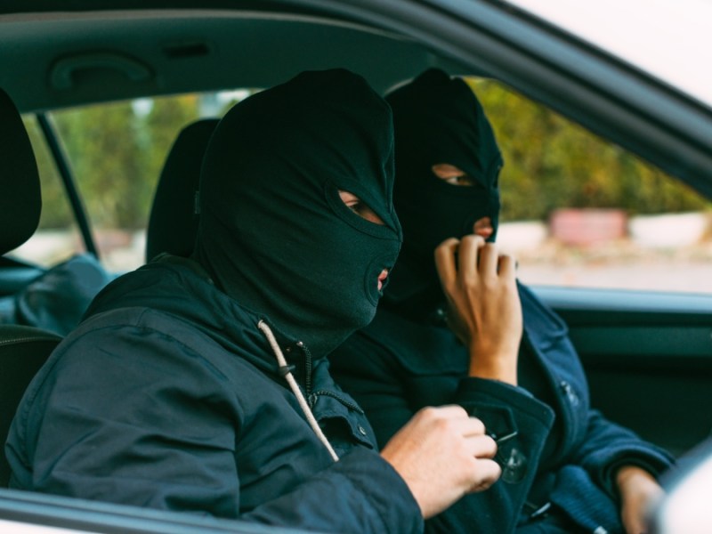 Gangster, die ihre Maske aufsetzen und sich auf den nächsten Raubüberfall vorbereiten.